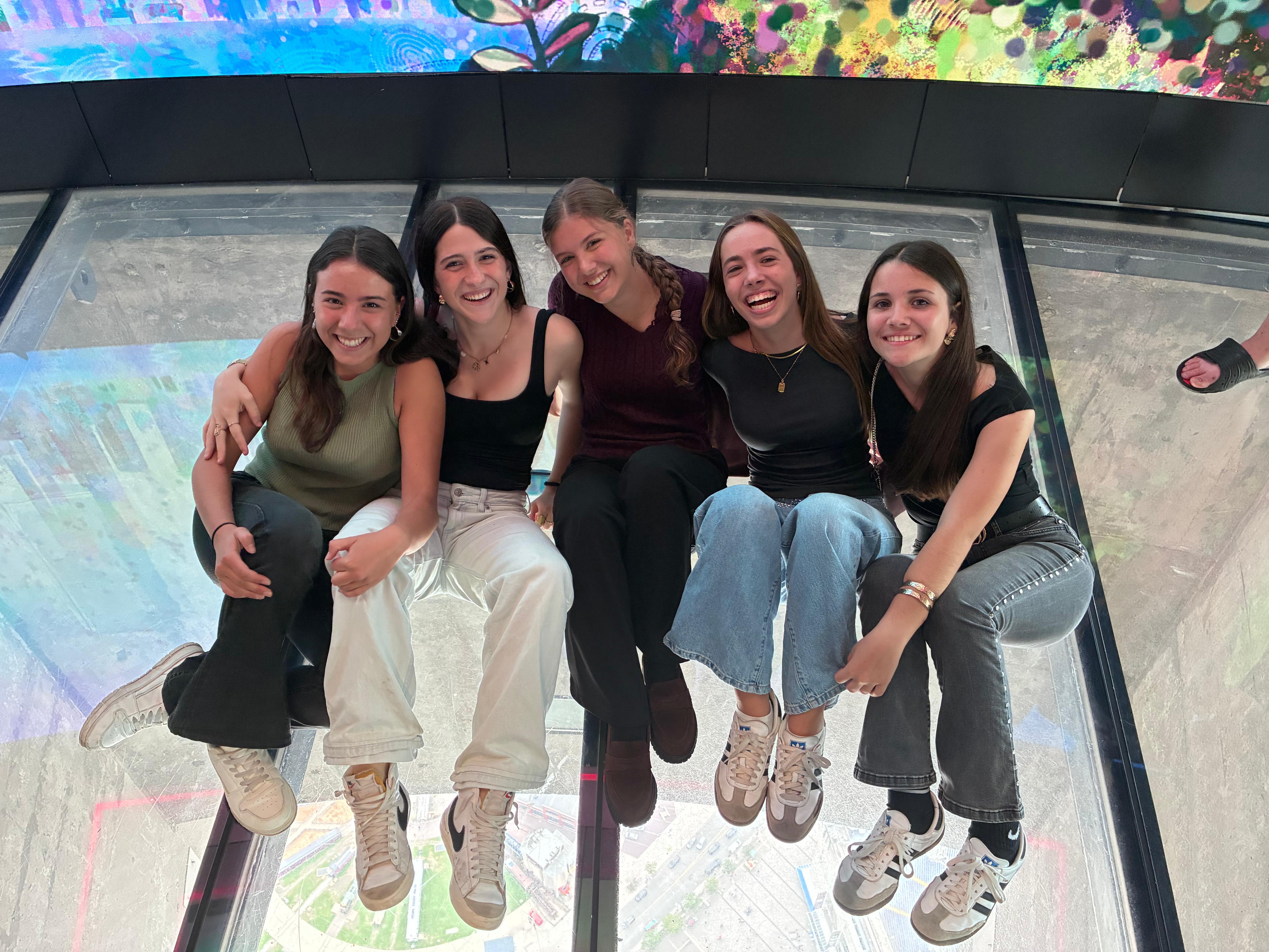 Martina y sus amigas sentadas en el suelo de cristal de la CN Tower en Toronto