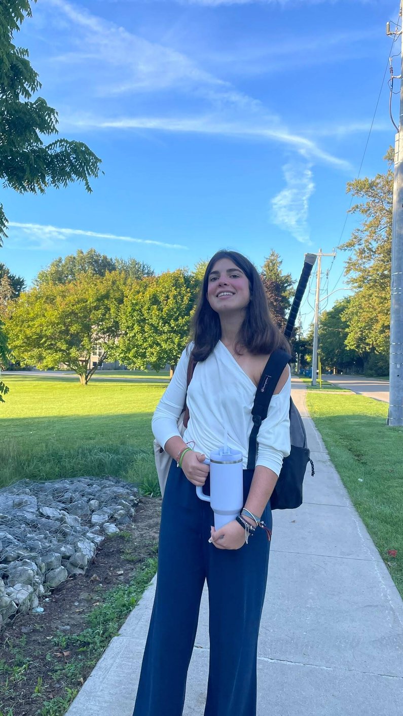 Carla camino al instituto, con su mochila y vaso térmico